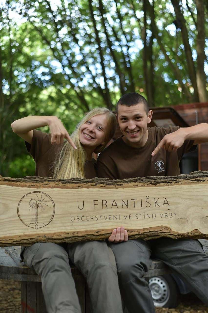 Tým U Františka u vyřezávané cedule